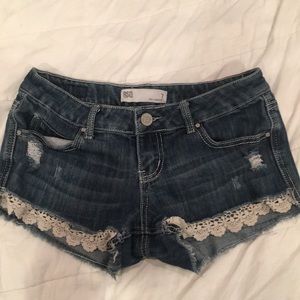 Blue jean shorts with lace at the bottom.